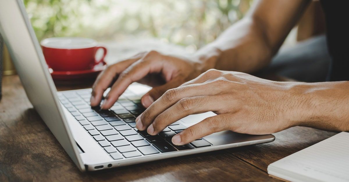 A man typing on the keyboard replying to an email invitation