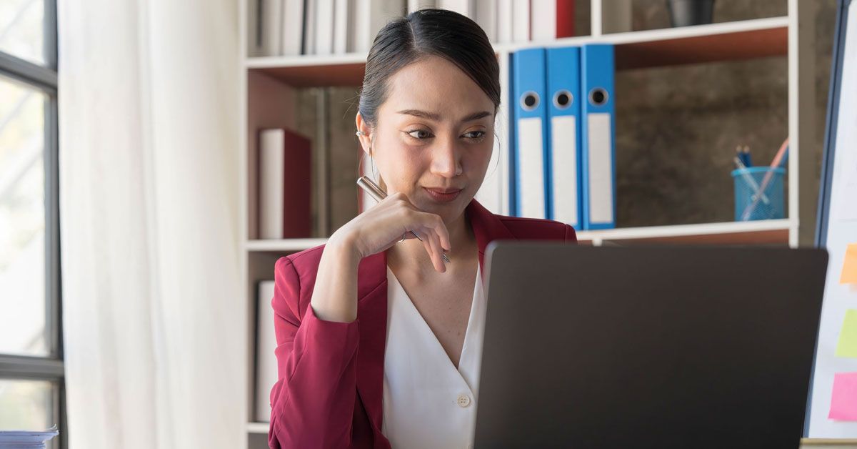 Focused woman working on a laptop, engrossed in her tasks