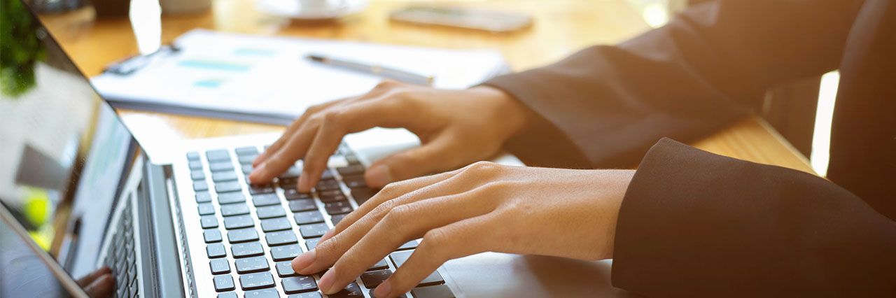Man typing an out of office message on his laptop